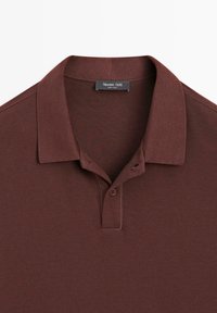 Brun kortærmet poloshirt med krave og to-knapsklap, med et Massimo Dutti-mærke indeni halsudskæringen.