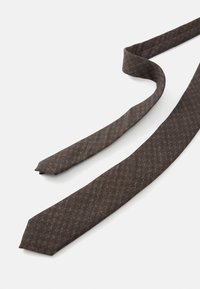 Cravate tissée marron avec un motif de losanges subtil, de forme longue et effilée, texture du tissu lisse mais durable, pointe aiguë.