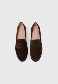 Pruun nahast loaferid lame tallaga, millel on ülemisel osal õmmeldud aktsent ja pehme roosa sisetald. Disain on sleek ja minimalistik.