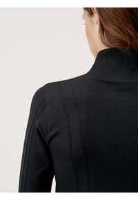 Black knitted sweater with a high collar, featuring textured horizontal and vertical stripes, displayed from the back.