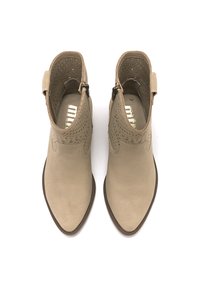 Botines beige con parte superior perforada, punta afilada y cremallera lateral. Textura suave con tacón bajo, con un sutil bordado decorativo.