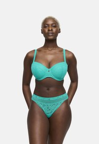 Turquoise kanten bh met voorgevormde cups en verstelbare bandjes, gecombineerd met bijpassende kanten string met een decoratieve tailleband.
