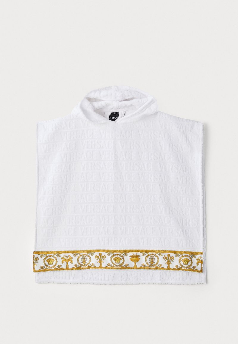 Biely froté pončo s embosovaným logom "VERSACE", ktoré má pozdĺž spodného okraja zlatý dekoratívny pás so zložitými vzormi.