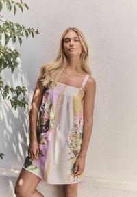 Kukallinen mekko, jossa on vaihtelevaa vaaleanpunaista väriä, erityisesti smokkikiinnitys ja ohuet hihnat, valmistettu kevyestä kankaasta.