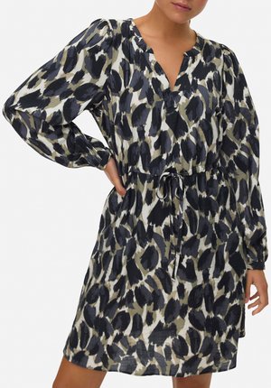 Robe imprimée avec un col en V et des manches longues, dotée d'une taille à cordon. Le motif comprend des formes abstraites noires et olive sur un fond clair.