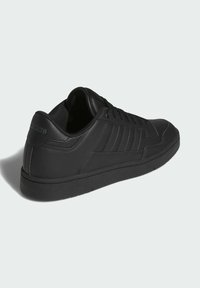 Černé kožené tenisky s texturovaným povrchem, šněrovacím designem, třemi postranními pruhy a polstrovaným límcem. Gumová podrážka s minimálním dezénem.