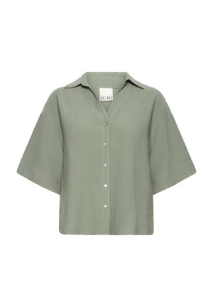 Short-sleeved olive green shirt with a collared neckline, button front, and textured fabric. Features a relaxed, boxy fit.