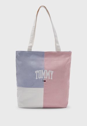 Sac fourre-tout avec des rayures verticales en blocs bleus, roses et blancs, avec "TOMMY" brodé en blanc et un petit drapeau rouge, blanc et bleu en dessous.