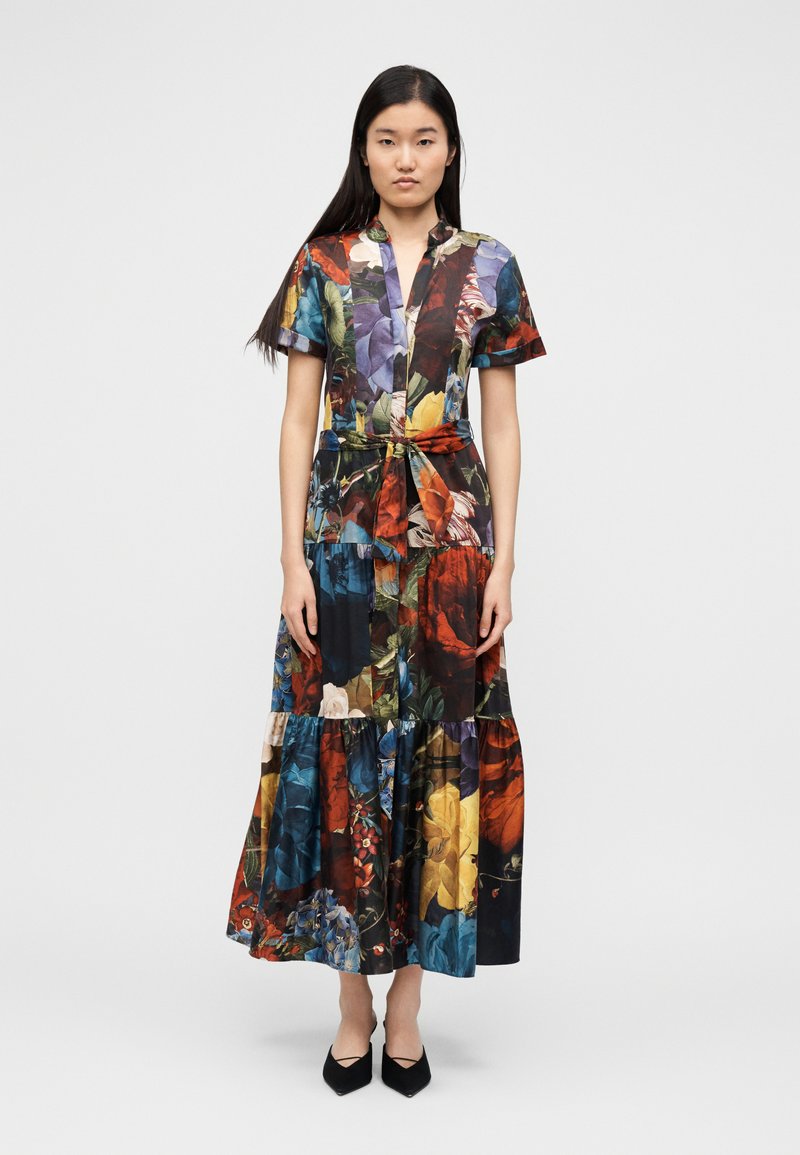 Lilledemustriga lühikeste varrukatega maksikleit vöökattega ja astmelise seelikuosaga; värvid punane, sinine, kollane ja roheline. Mustad kingad.