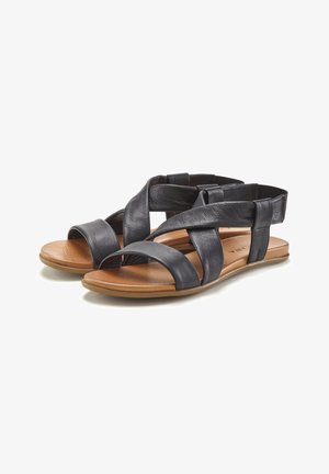 Schwarze Leder-Sandalen mit gekreuzten Riemen, offenem Zehendesign und flacher brauner Sohle. Weiche Textur mit verstellbarem hinterem Riemen für eine optimale Passform.