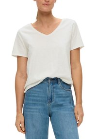 Witte T-shirt met korte mouwen en V-hals van zacht katoen, in een relaxte pasvorm, gecombineerd met blauwe high-waisted denim jeans.