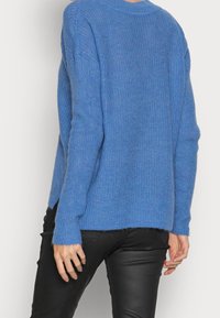 Blauer gestrickter Pullover mit lockerem Schnitt, langen Ärmeln, rundem Ausschnitt und einem weichen, strukturierten Stoff.