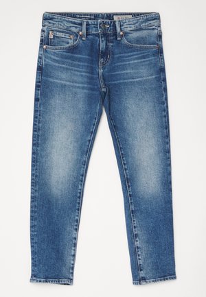 Siniset slim-fit farkut, joissa on haalistumat, etupainike ja viisi taskua, levitettynä valkoiselle taustalle.