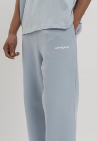LOW LIGHTS STUDIOS® BASIC LOGO JOGGER - Pantalones deportivos - sky blue
