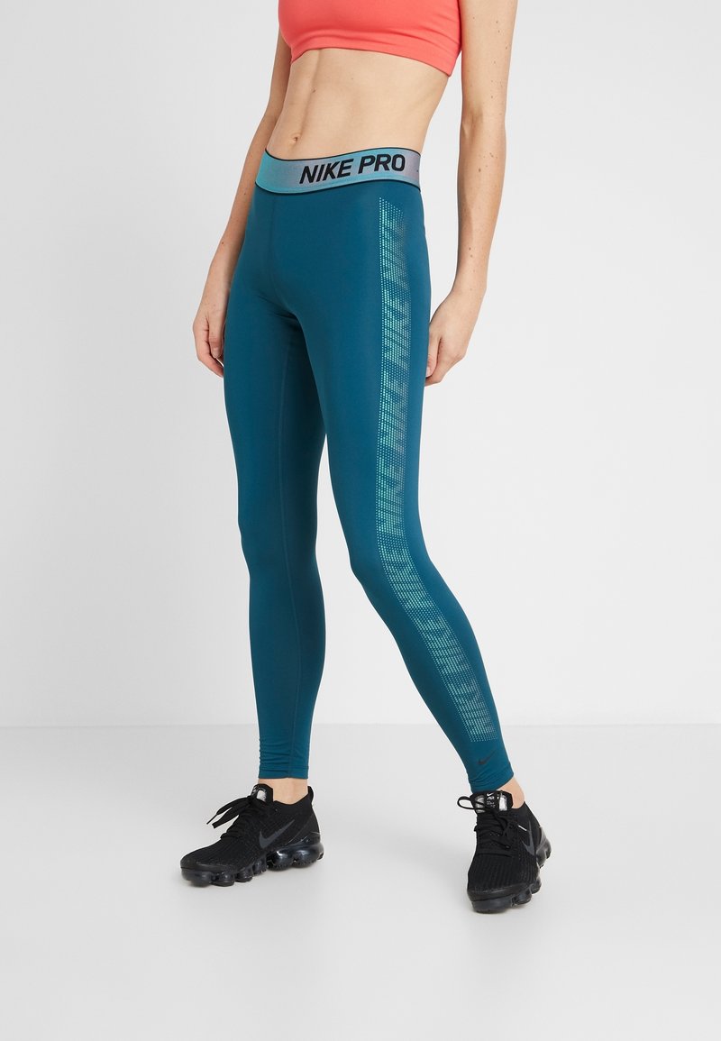 Leggings Nike Pro in tonalità verde acqua con una ampia vita nera che presenta il testo "NIKE PRO", dettaglio a strisce testurizzate lungo il lato e un design aderente.