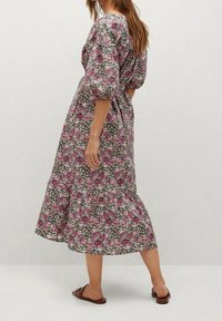 Robe midi florale dans des tons de rose et de vert, avec des manches bouffantes, une taille cintrée et un tissu texturé avec un motif.