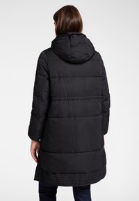 Czarna pikowana kurtka z kapturem, z poziomymi przeszyciami, dłuższym tylnym obrzeżem oraz długimi rękawami z prążkowanymi wykończeniami.