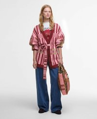 Knitted cardigan with a checkered pattern in pink and burgundy, paired with wide blue jeans and a patterned tote bag.