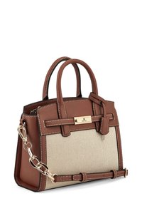 Brązowa skórzana torba na ramię z beżowym płóciennym korpusem, złotymi elementami wykończenia, podwójnymi uchwytami, odpinanym paskiem na ramię oraz kontrastowymi szwami.