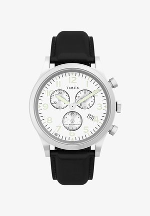 Timex Waterbury kellal on hõbedane roostevabast terasest korpus, valge sihverplaat, must nahkrihm, kolm aladiagrammi ja kuupäeva näit.