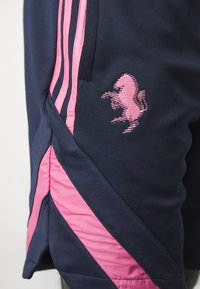 Tengeralattjáró színű sportnadrág pink oldalsávokkal és pink hímzett ló logóval a bal combon, lélegző anyagból készült.