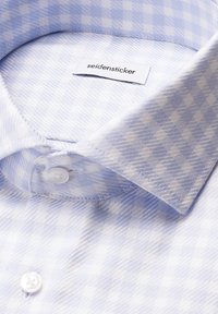 Colletto di camicia a scacchi blu e bianchi, con un motivo testurizzato. Presenta un'etichetta con la scritta "seidensticker" e bottoni bianchi sul davanti.