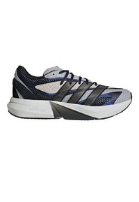 Baskets de sport noires, grises et blanches avec tige en mesh, rayures noires, semelle intermédiaire gris clair étiquetée "LIGHTSTRIKE" et lacets noirs.
