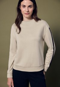 Beige mikina s vysokým límcem, žebrovanými manžetami a kontrastními černými bočními akcenty. Hladká textura, volný střih.