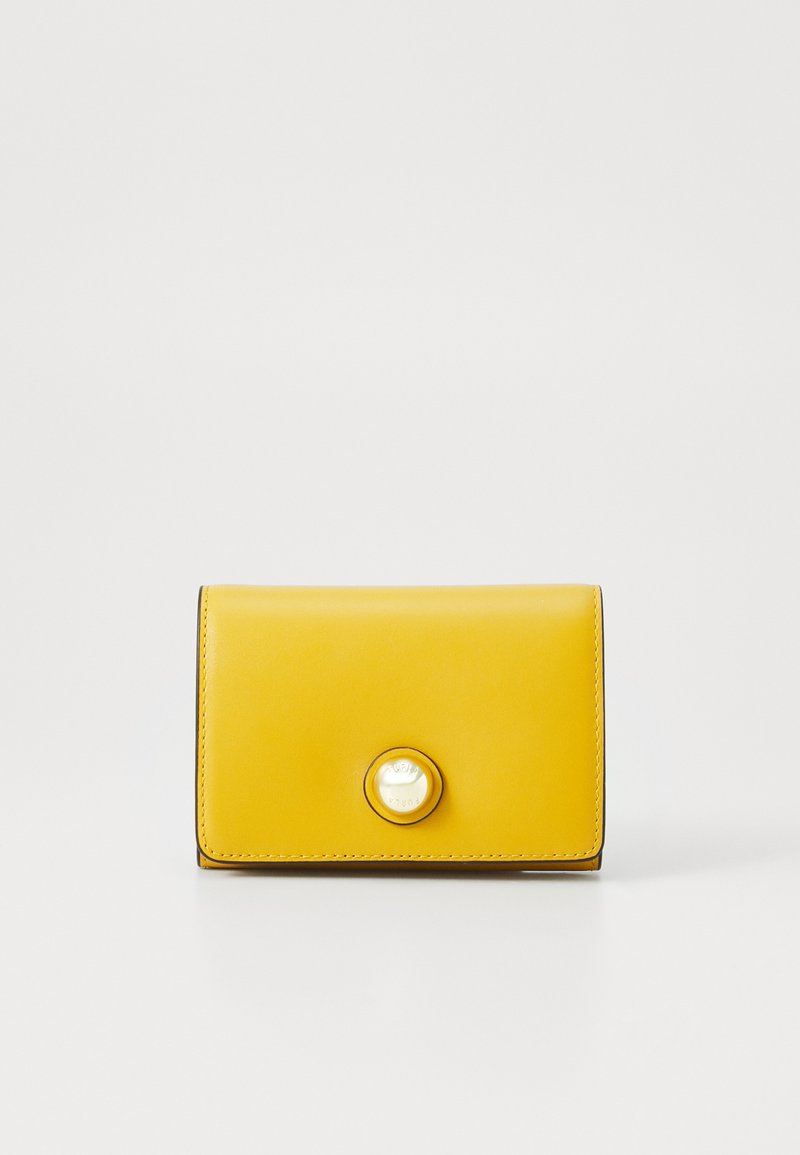 Portefeuille en cuir jaune avec une texture lisse, design à rabat et fermeture à bouton circulaire proéminent. Les bords sont soigneusement cousus.