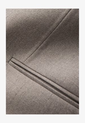 Tejido gris texturizado con un sutil patrón de cuadrícula, con costuras visibles y un elegante detalle de bolsillo en la superficie.