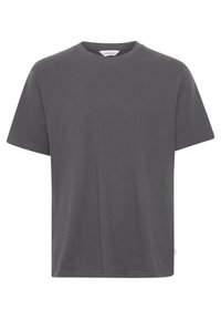 Camiseta gris de manga corta hecha de algodón, con un escote redondo y un corte relajado. Sin patrones o adornos visibles.