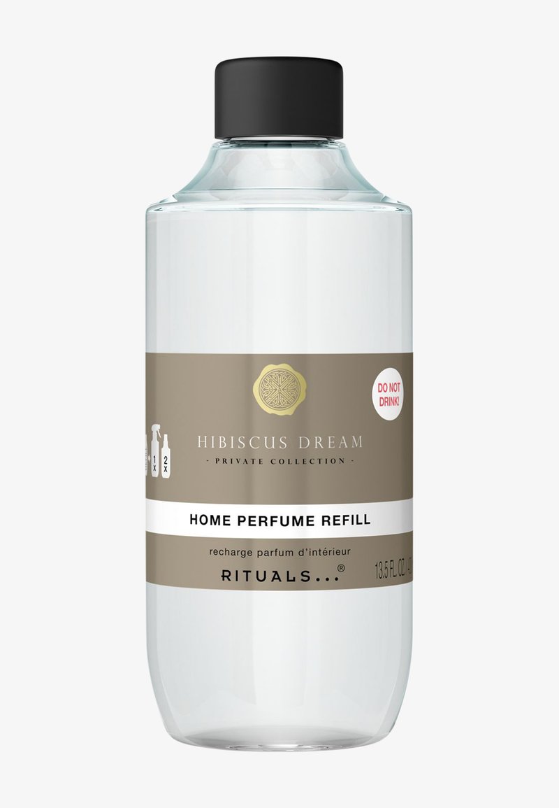 Przezroczysta szklana butelka z czarną nakrętką, oznaczona etykietą "Hibiskusowy Sen - Uzupełnienie Perfum do Domu." Złote i białe napisy; pojemność 13,5 fl oz.