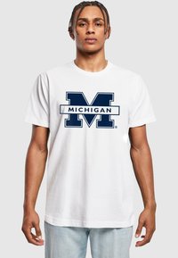 Bílý bavlněný tričko s velkým námořnickým logem "MICHIGAN" a výrazným designem "M". Krátké rukávy, kulatý výstřih, volný střih.