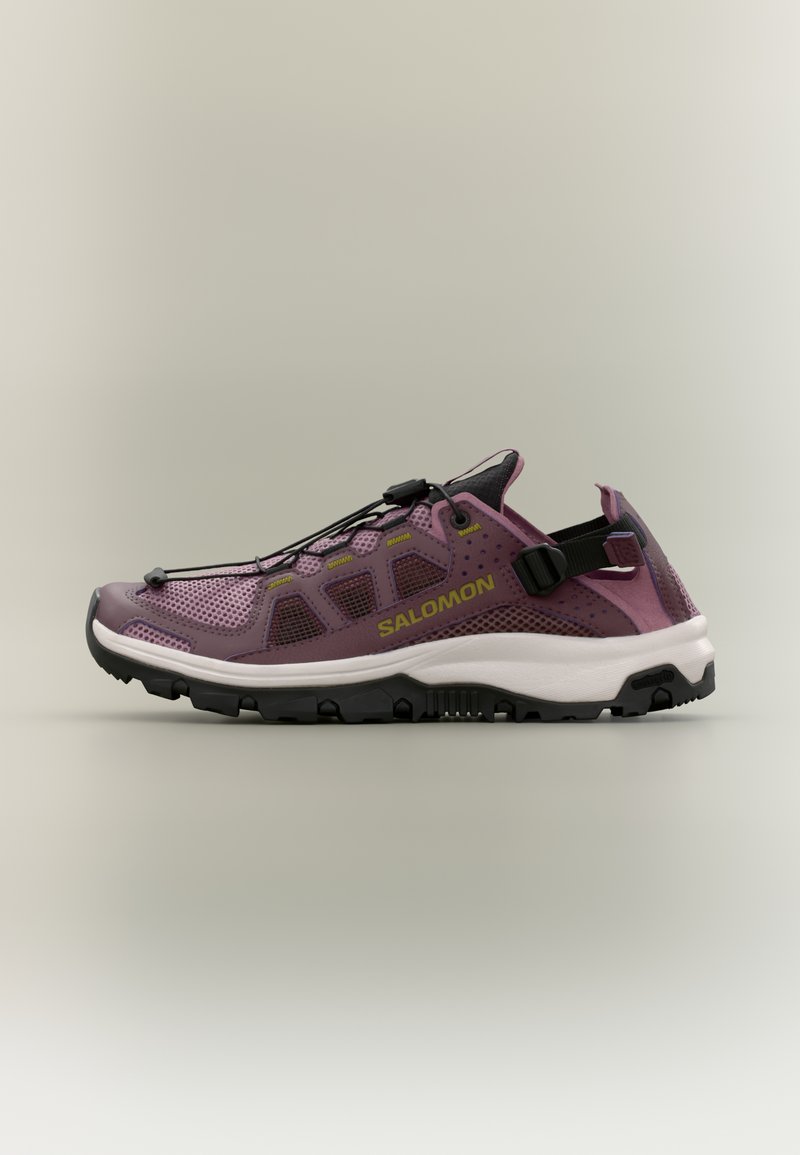 Μωβ και μαύρο παπούτσι για τρέξιμο σε μονοπάτια της Salomon με επάνω μέρος από δίχτυ, ρυθμιζόμενα κορδόνια, ανθεκτική μαύρη σόλα και λευκή μέση σόλα, πλευρική όψη.