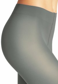Graue High-Waist-Leggings mit strukturiertem Rippdesign und glatter Oberfläche. Mit einer Naht entlang der Seite, die ein eng anliegendes Design präsentiert.