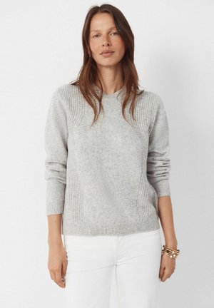 Lysegrå strikket sweater med rund halsudskæring, ribstrikkede manchetter og detaljer på sidepanelerne; lavet af blødt, tekstureret stof.