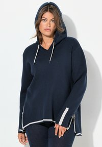 Navyblauer Kapuzenpullover mit Kordelzug, langen Ärmeln und kontrastierenden weißen Akzenten an den Bündchen und am Saum. Verfügt über seitliche Reißverschlüsse für ein zusätzliches Design.