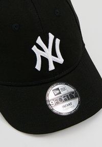 Schwarze New Era 9FORTY Mütze für Kleinkinder, mit einem weißen gestickten Logo der New York Yankees und einem silbernen verstellbaren Größenaufkleber.