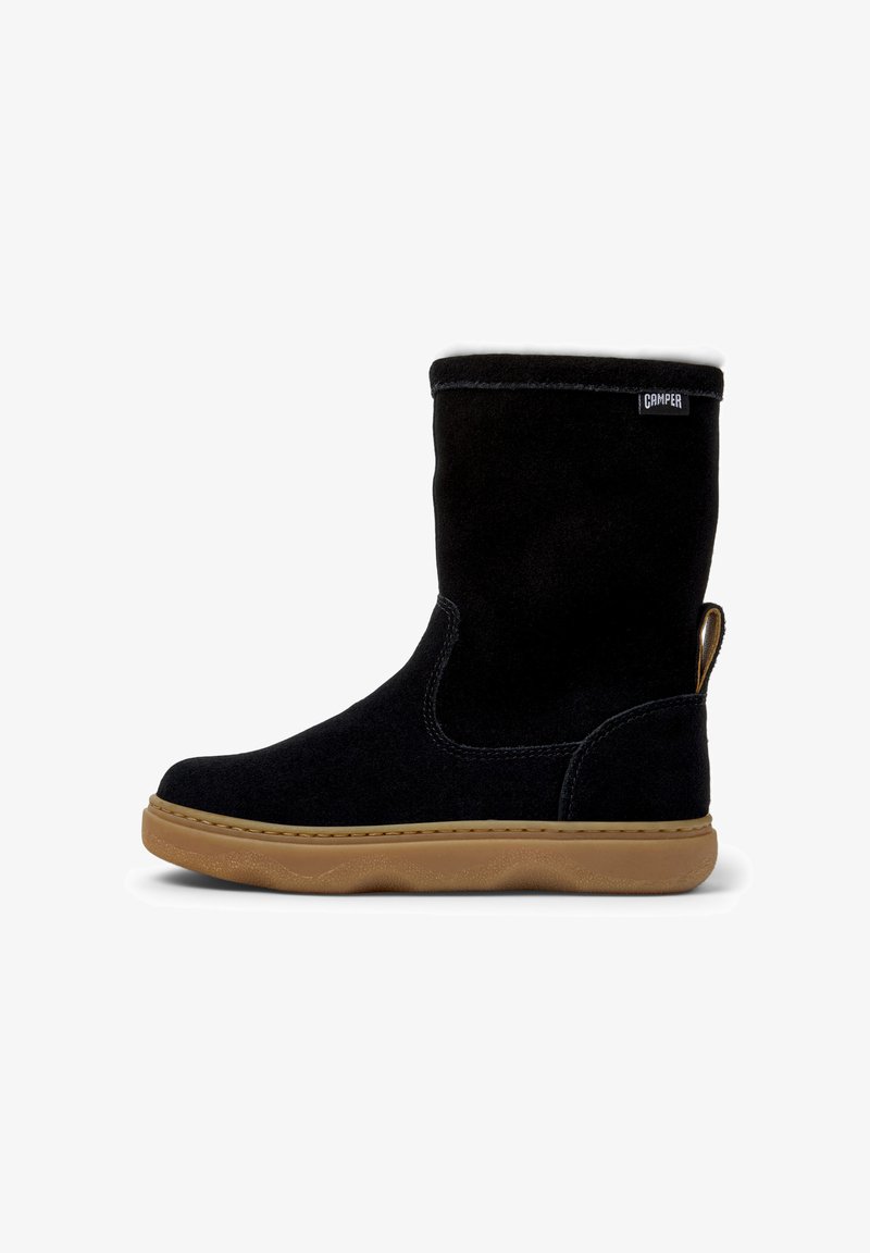 Schwarz Wildleder Stiefel bis zur Wade mit heller Gummisohle, Zuglasche an der Ferse und einem kleinen Camper-Logo nahe der oberen Kante.