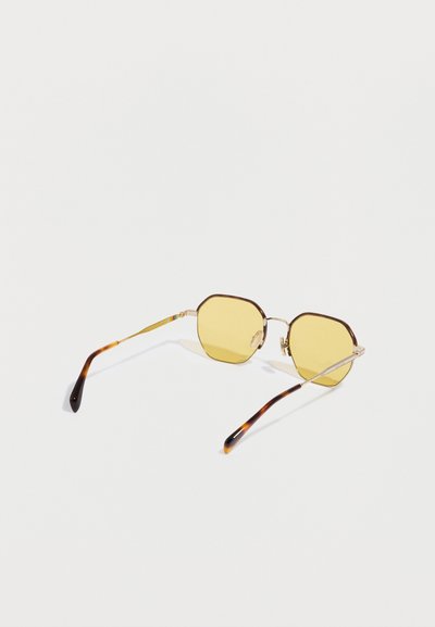 Occhiali da sole ottagonali con lenti gialle, montatura in metallo e aste con motivo tartarugato. Presentano dettagli dorati e naselli.