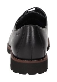 Scarpa in pelle nera con tacco basso, punta rotonda e superficie texturizzata. Presenta cuciture marrone chiaro e una suola a tassello per una migliore aderenza.
