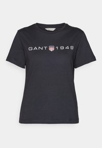Sort kortærmet T-shirt med rund hals, med "GANT 1949" tekst og skjoldlogo med stjerner og striber på brystet.