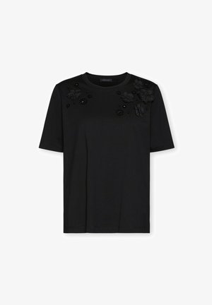 Schwarzes T-Shirt mit kurzen Ärmeln und rundem Ausschnitt, verziert mit schwarzen Blumenapplikationen und Perlenverzierungen auf der oberen Vorderseite.