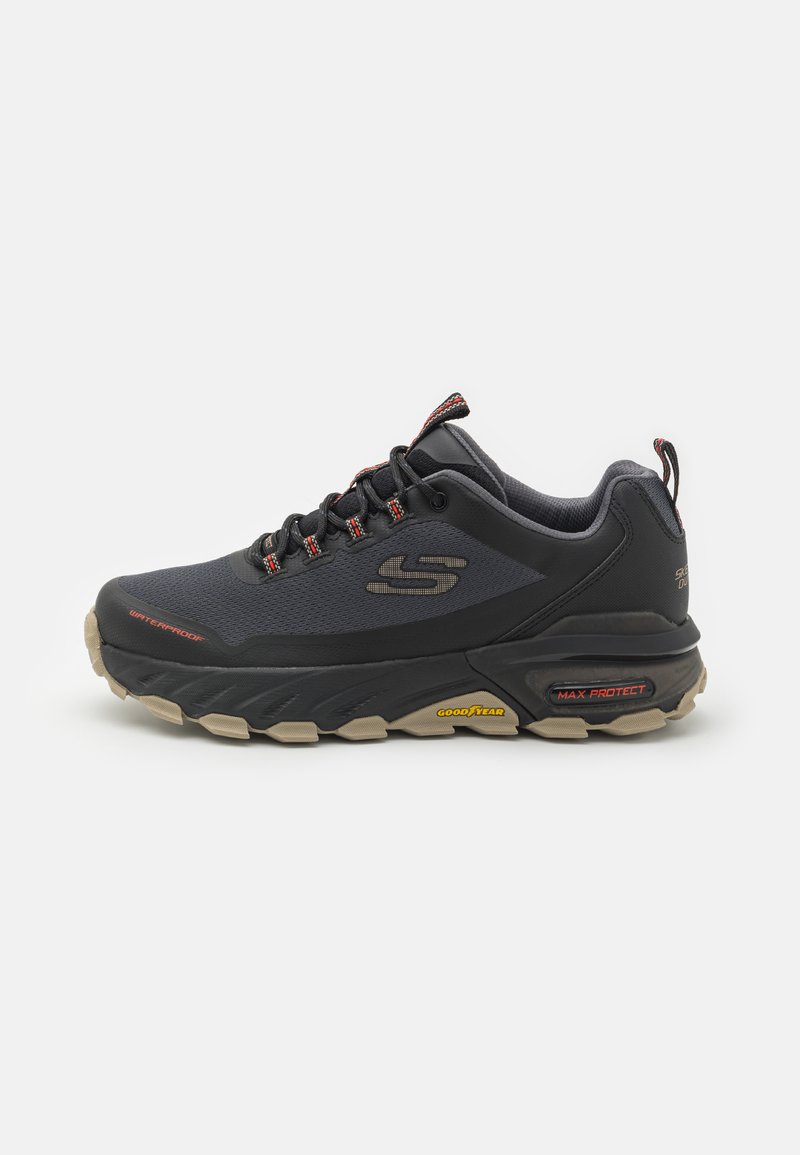 Black waterproof sneaker with a textured synthetic upper, elastic laces, and a rubber outsole featuring prominent tread patterns and branding.