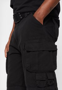 Sorte cargo shorts med flere sidelommer, lavet af holdbart stof, med et struktureret bælte og rene syninger.