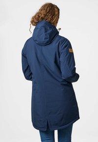 Granatowa wodoodporna parka z kapturem, z łatą z logo na ramieniu, o długości średniej oraz z wentylacją z tyłu dla lepszej cyrkulacji powietrza.