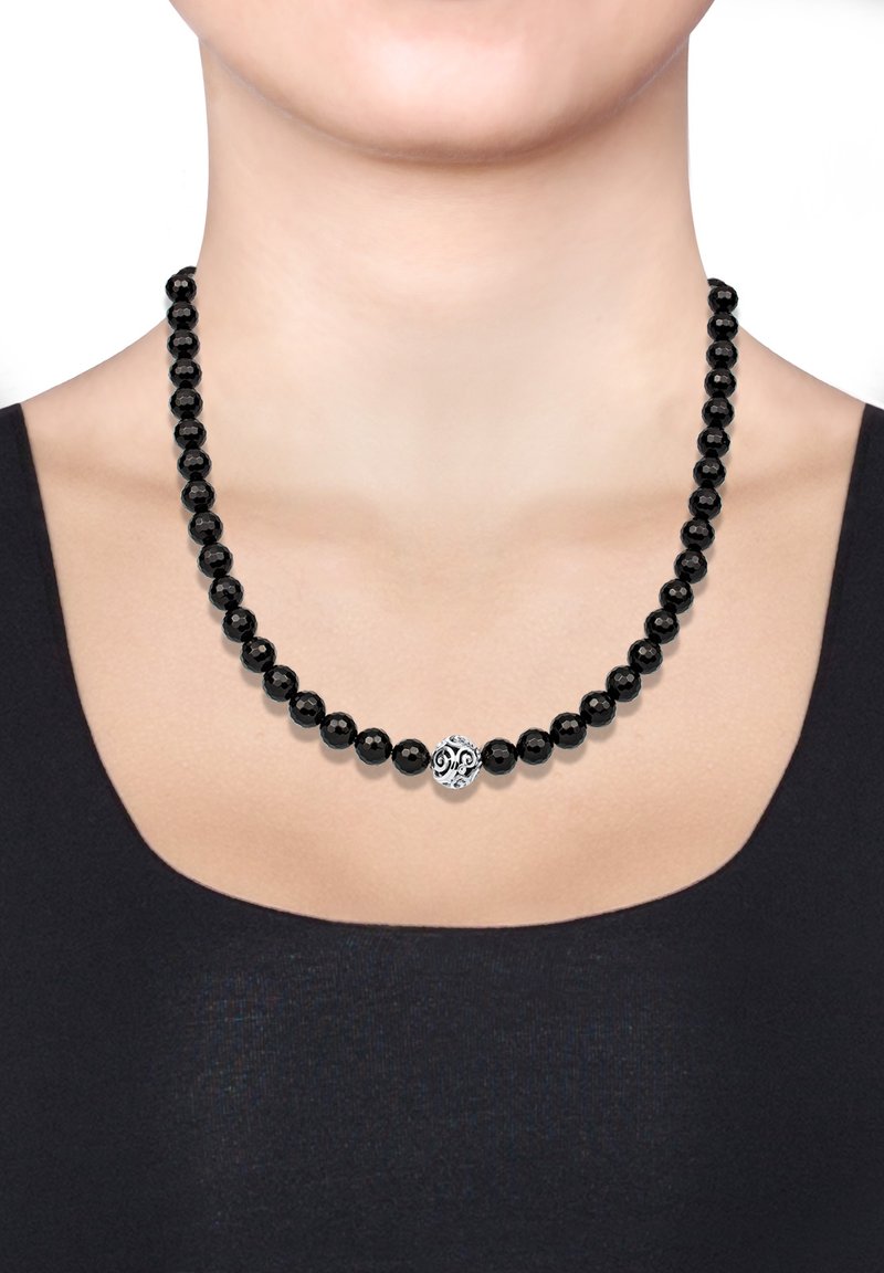 Sorte perle halskæde med runde, glansfulde perler; har en dekorativ sølv midterdel med intrikate mønstre. Båret om halsen.