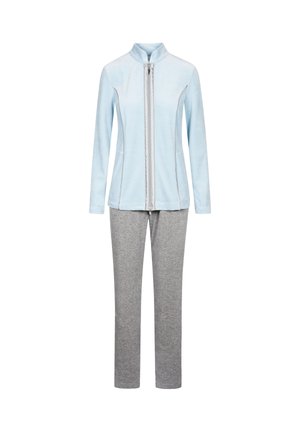 Lyseblå lynlåstrøje med høj krave, kombineret med grå træningsbukser. Jakken har sidelommer og en blød tekstur.