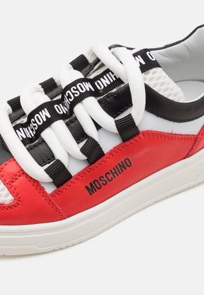 Punane ja must nahast toss, millel on valged võrgupaneelid, julged valged paelad ning must "MOSCHINO" logo külgedel.