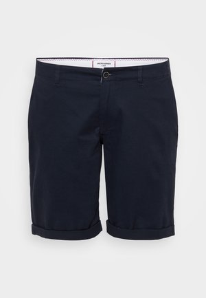 Tumesinised lühikesed püksid, mis on valmistatud puuvillast kangast, millel on lame eesmine osa, rullitud servad ja üks eesmine nööpkinnitus.